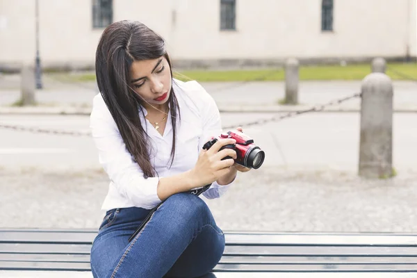 Genç kadın sokak şehir üzerinde kırmızı kamera ile fotoğraf çekmek