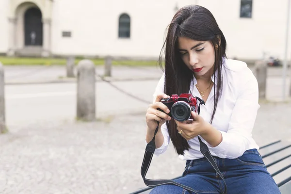 Genç kadın sokak şehir üzerinde kırmızı kamera ile fotoğraf çekmek