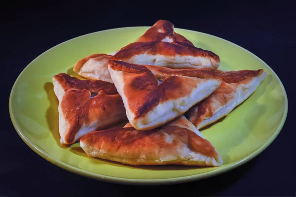 Homemade meat pies belyashi on a dish on a dark background. — Stockfoto