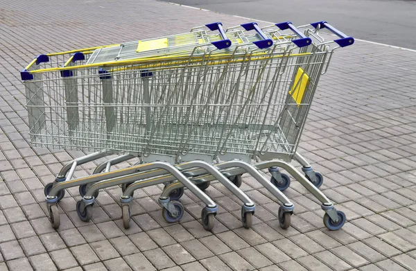 Nahaufnahme leerer Einkaufswagen auf dem Bürgersteig am Eingang zum Geschäft. — Stockfoto