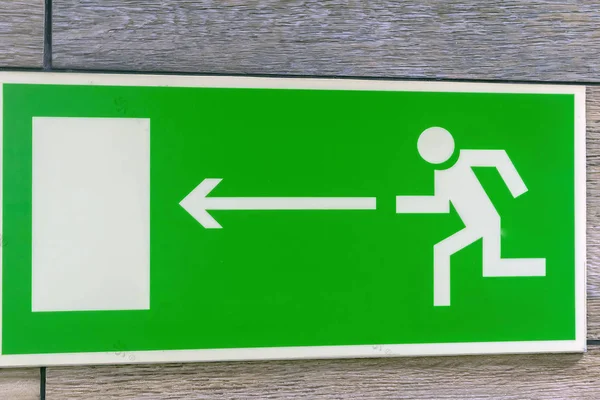 Sign with arrow pointing direction emergency exit from the building. — Stock Photo, Image