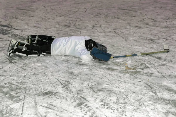 A védő egyenruhás hoki kapus a jégen fekszik, közelről.. — Stock Fotó