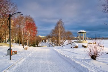 Kış mevsimi, gün batımında şehrin göletindeki ilk kar manzarası. Parkın ilk karı..