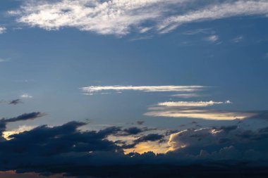 Gün batımında gökyüzü. Kümülüs bulutları batan güneşin ışınlarıyla aydınlatıldı.