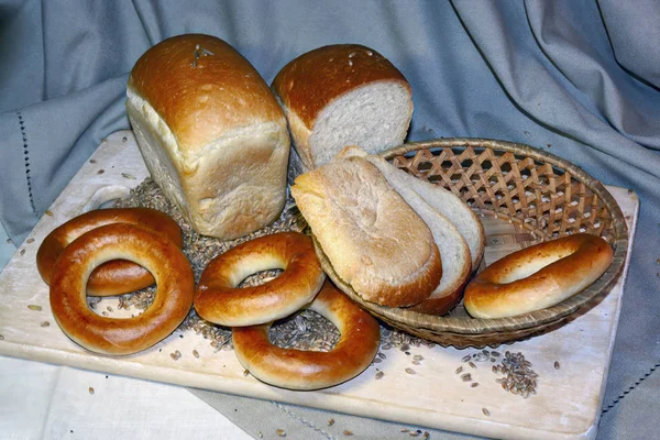 Eine Auswahl an frisch gebackenen Broten. Sortiment von gebackenem Brot auf Holztischhintergrund. — Stockfoto