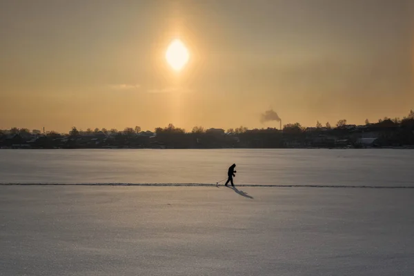 Skier przecina zamarznięty staw. Narciarz na torze w słoneczny zimowy poranek. — Zdjęcie stockowe