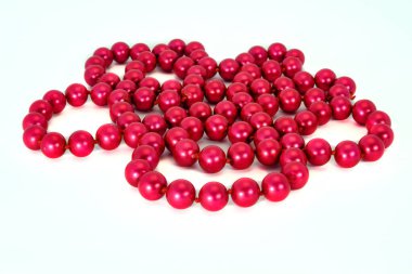 İnci kolye, beyaz arka planda yakın plan çekimde izole edilmiş. Güzel kırmızı boncuklar beyazda izole edilmiş.