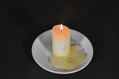 Koyu bir arkaplanda yanan mumun yakınlaştırılması.