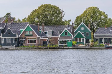 Hollanda kırsal manzarası: Zaanse Schans yakınlarındaki nehir kıyısındaki küçük Hollanda köyü manzarası. Hollanda 'da..