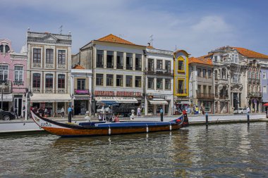 Aveiro, Portekiz - 20 Nisan 2017: Güneşli bir günde kanal üzerinde geleneksel Moliceiro teknelerinin (gondollar) bulunduğu ana şehir kanalı ve Vouga Nehri manzarası.