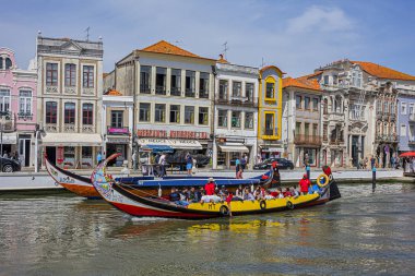 Aveiro, Portekiz - 20 Nisan 2017: Güneşli bir günde kanal üzerinde geleneksel Moliceiro teknelerinin (gondollar) bulunduğu ana şehir kanalı ve Vouga Nehri manzarası.