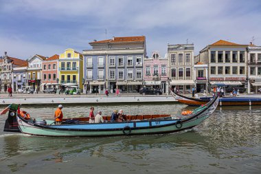 Aveiro, Portekiz - 20 Nisan 2017: Güneşli bir günde kanal üzerinde geleneksel Moliceiro teknelerinin (gondollar) bulunduğu ana şehir kanalı ve Vouga Nehri manzarası.