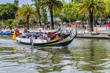 Aveiro, Portekiz - 20 Nisan 2017: Güneşli bir günde kanal üzerinde geleneksel Moliceiro teknelerinin (gondollar) bulunduğu ana şehir kanalı ve Vouga Nehri manzarası.