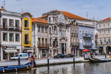 Aveiro, Portekiz - 20 Nisan 2017: Güneşli bir günde kanal üzerinde geleneksel Moliceiro teknelerinin (gondollar) bulunduğu ana şehir kanalı ve Vouga Nehri manzarası.