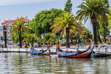 Aveiro, Portekiz - 20 Nisan 2017: Güneşli bir günde kanal üzerinde geleneksel Moliceiro teknelerinin (gondollar) bulunduğu ana şehir kanalı ve Vouga Nehri manzarası.