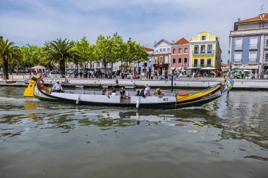 Aveiro, Portekiz - 20 Nisan 2017: Güneşli bir günde kanal üzerinde geleneksel Moliceiro teknelerinin (gondollar) bulunduğu ana şehir kanalı ve Vouga Nehri manzarası.