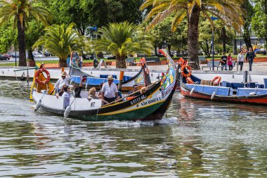 Aveiro, Portekiz - 20 Nisan 2017: Güneşli bir günde kanal üzerinde geleneksel Moliceiro teknelerinin (gondollar) bulunduğu ana şehir kanalı ve Vouga Nehri manzarası.