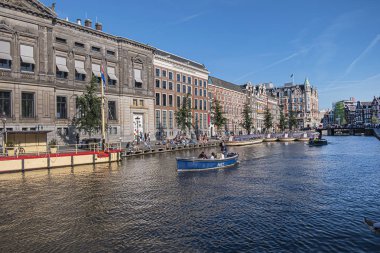 Amsterdam, Hollanda - 22 Ağustos 2019: Rokin Amsterdam Kanalı boyunca güzel manzara: tekneler, inşaat ve insanlar. Aslen, Rokin Kanalı Amstel Nehri 'nin bir parçasıydı..