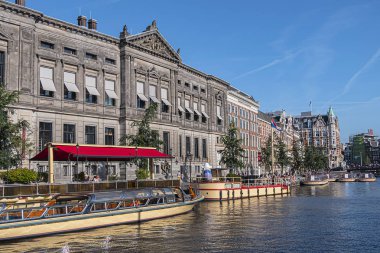 Amsterdam, Hollanda - 22 Ağustos 2019: Rokin Amsterdam Kanalı boyunca güzel manzara: tekneler, inşaat ve insanlar. Aslen, Rokin Kanalı Amstel Nehri 'nin bir parçasıydı..