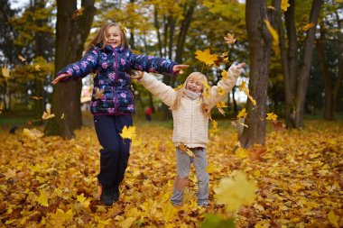 parkta oynayan iki küçük kız kardeş