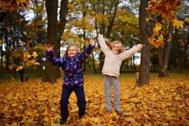 parkta oynayan iki küçük kız kardeş