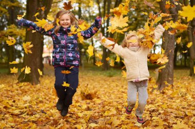 parkta oynayan iki küçük kız kardeş