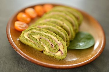 Tabağında peynir olan ıspanak ruleti.