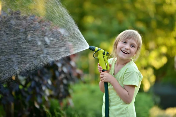 Schattig klein meisje drenken bloemen drenken — Stockfoto