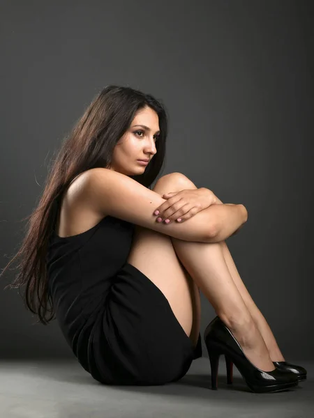 Vacker kvinna poserar i studio på mörk bakgrund — Stockfoto