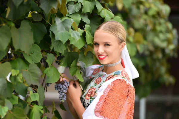 Mujer sonriente mantiene las uvas en las manos al aire libre —  Fotos de Stock