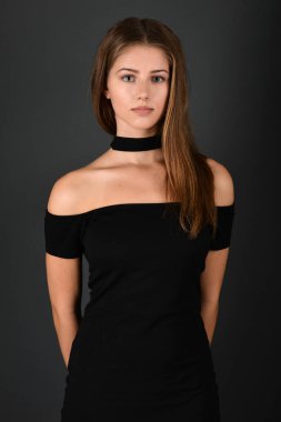 gri arka plan üzerinde poz siyah elbiseli genç esmer Bayan