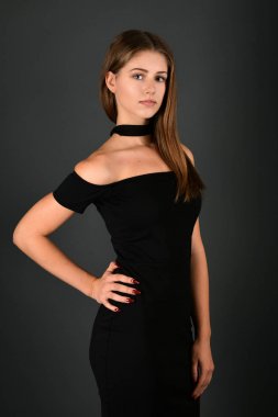 gri arka plan üzerinde poz siyah elbiseli genç esmer Bayan