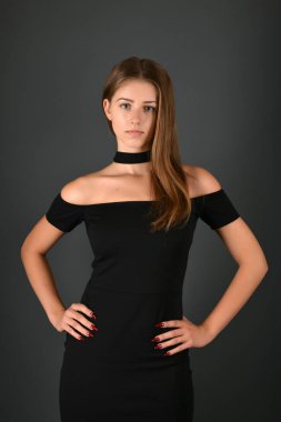 gri arka plan üzerinde poz siyah elbiseli genç esmer Bayan