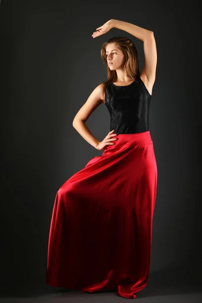 Jovem morena de vestido preto posando no fundo cinza — Fotografia de Stock