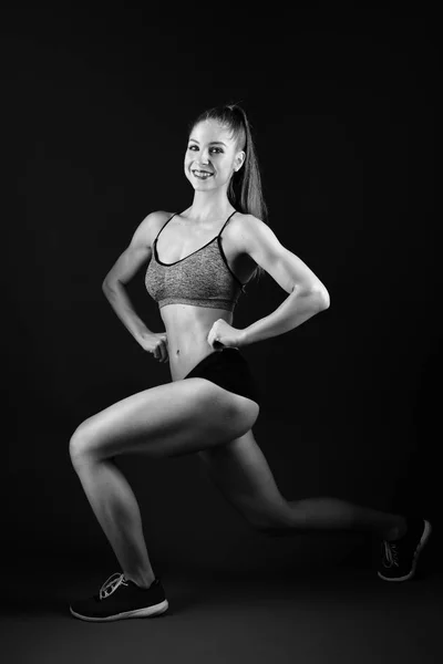Brutala atletisk kvinna pumpa upp muskler med hantlar — Stockfoto