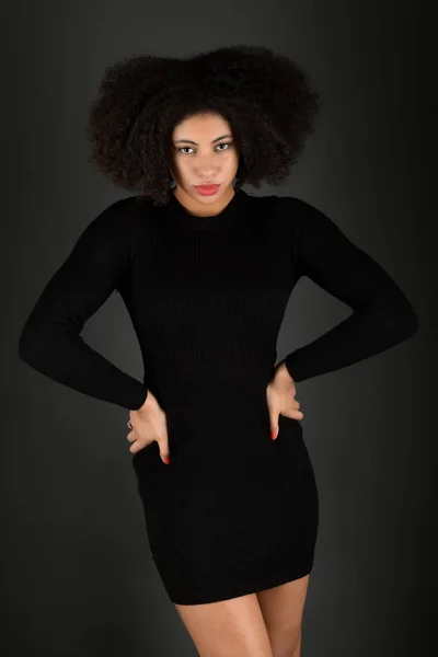 Young black woman with afro hairstyle smiling.