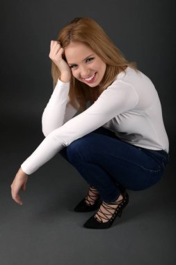 Siyah arka planda güzel, seksi sarışın kadın.