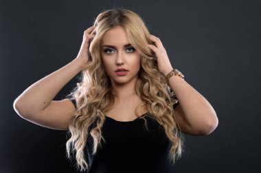 Sarışın kız parlak dalgalı saçlı uzun ve hacim. Güzel bir kadın modeli kıvırcık saç modeli ile .