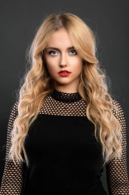 Sarışın kız parlak dalgalı saçlı uzun ve hacim. Güzel bir kadın modeli kıvırcık saç modeli ile .