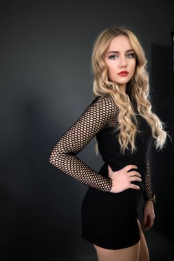 Sarışın kız parlak dalgalı saçlı uzun ve hacim. Güzel bir kadın modeli kıvırcık saç modeli ile .