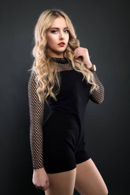 Sarışın kız parlak dalgalı saçlı uzun ve hacim. Güzel bir kadın modeli kıvırcık saç modeli ile .