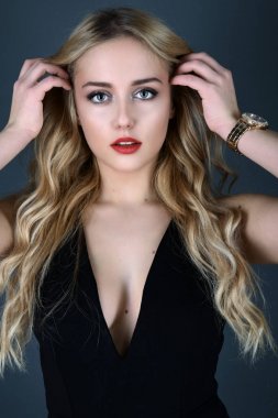 Sarışın kız parlak dalgalı saçlı uzun ve hacim. Güzel bir kadın modeli kıvırcık saç modeli ile .