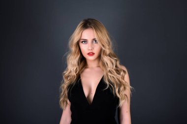 Sarışın kız parlak dalgalı saçlı uzun ve hacim. Güzel bir kadın modeli kıvırcık saç modeli ile .