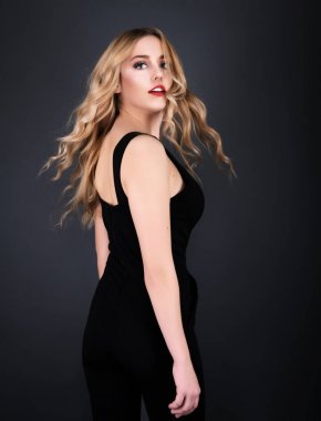 Sarışın kız parlak dalgalı saçlı uzun ve hacim. Güzel bir kadın modeli kıvırcık saç modeli ile .