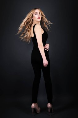 Sarışın kız parlak dalgalı saçlı uzun ve hacim. Güzel bir kadın modeli kıvırcık saç modeli ile .