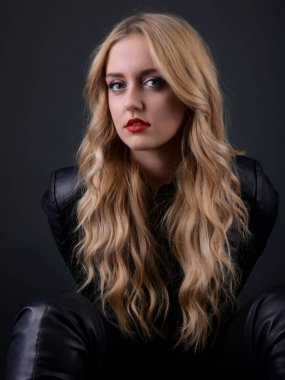 Sarışın kız parlak dalgalı saçlı uzun ve hacim. Güzel bir kadın modeli kıvırcık saç modeli ile .