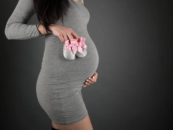 Retrato Estudio Una Hermosa Mujer Embarazada Con Botines Bebé Mano —  Fotos de Stock