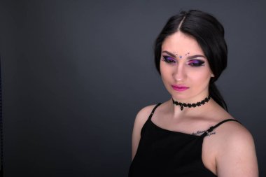 Yüzünü kapat. Gri arka plan üzerinde izole seksi elbiseli genç Arap kadın