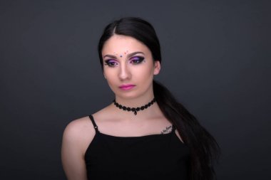 Yüzünü kapat. Gri arka plan üzerinde izole seksi elbiseli genç Arap kadın