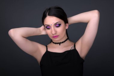 Yüzünü kapat. Gri arka plan üzerinde izole seksi elbiseli genç Arap kadın